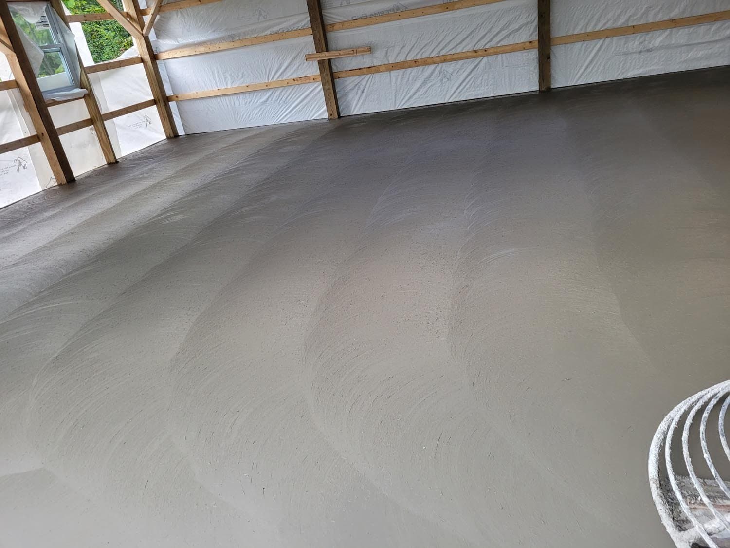 Smooth gray concrete floor with trowel marks in building under construction
