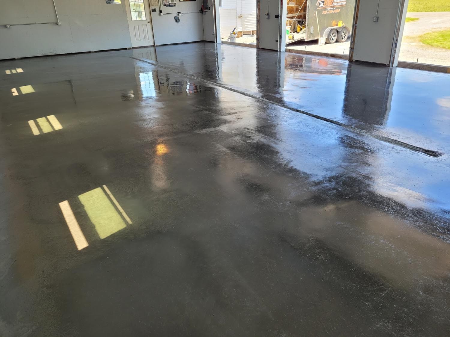Freshly poured and smoothed concrete garage floor with glossy wet surface