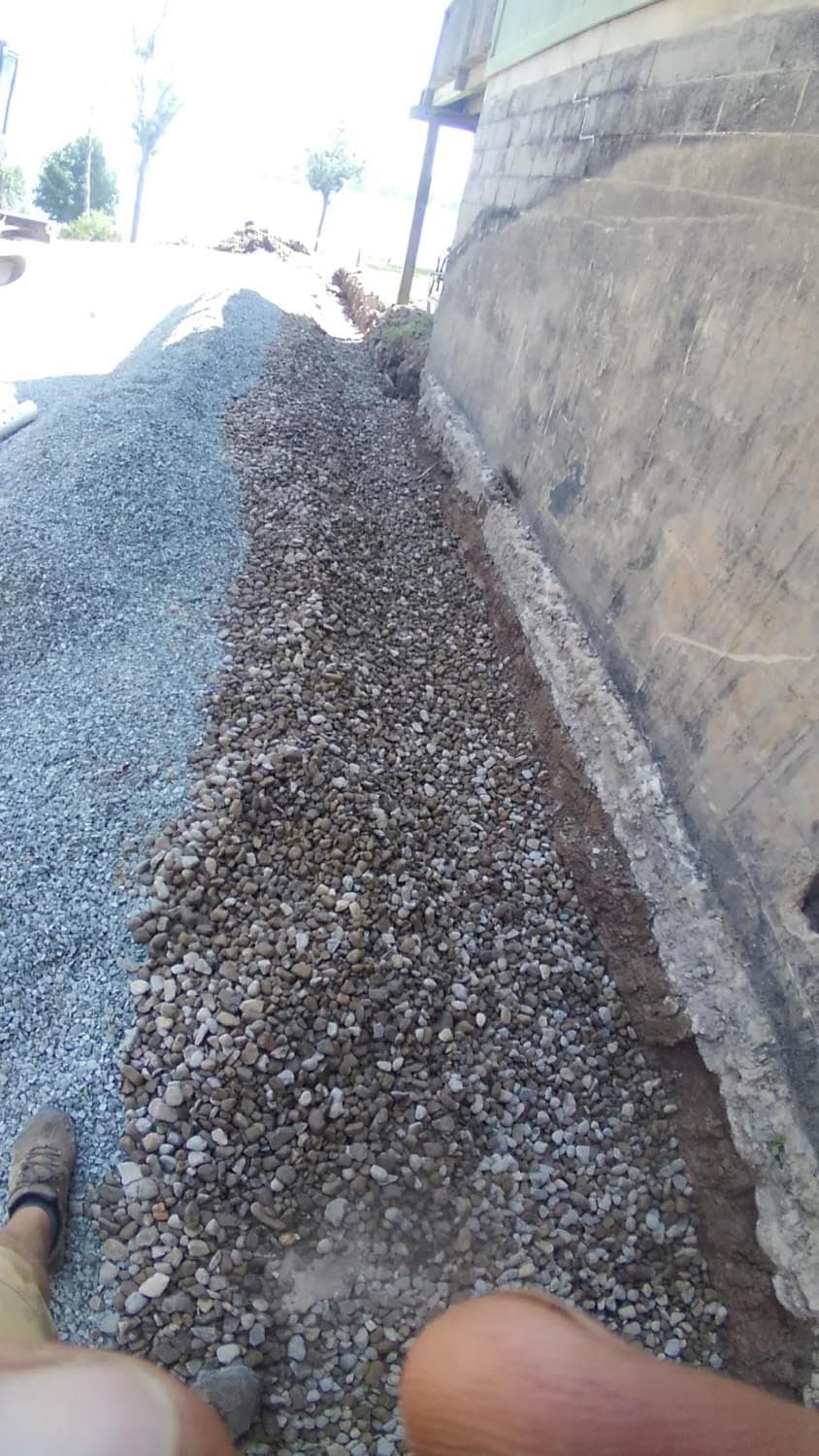 Gravel drainage trench installed along concrete foundation wall