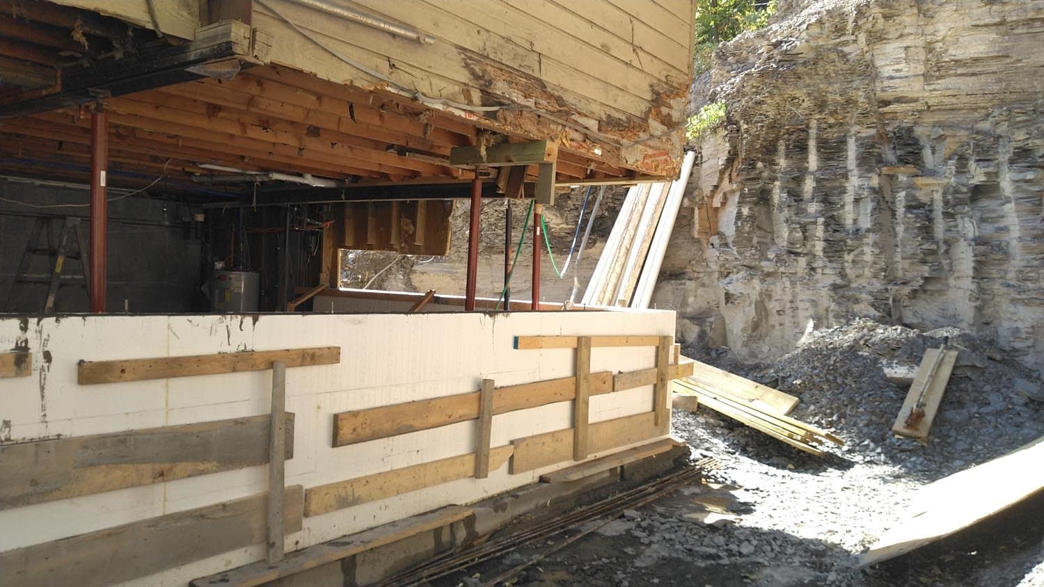 Excavated foundation site with exposed concrete walls and wooden framework