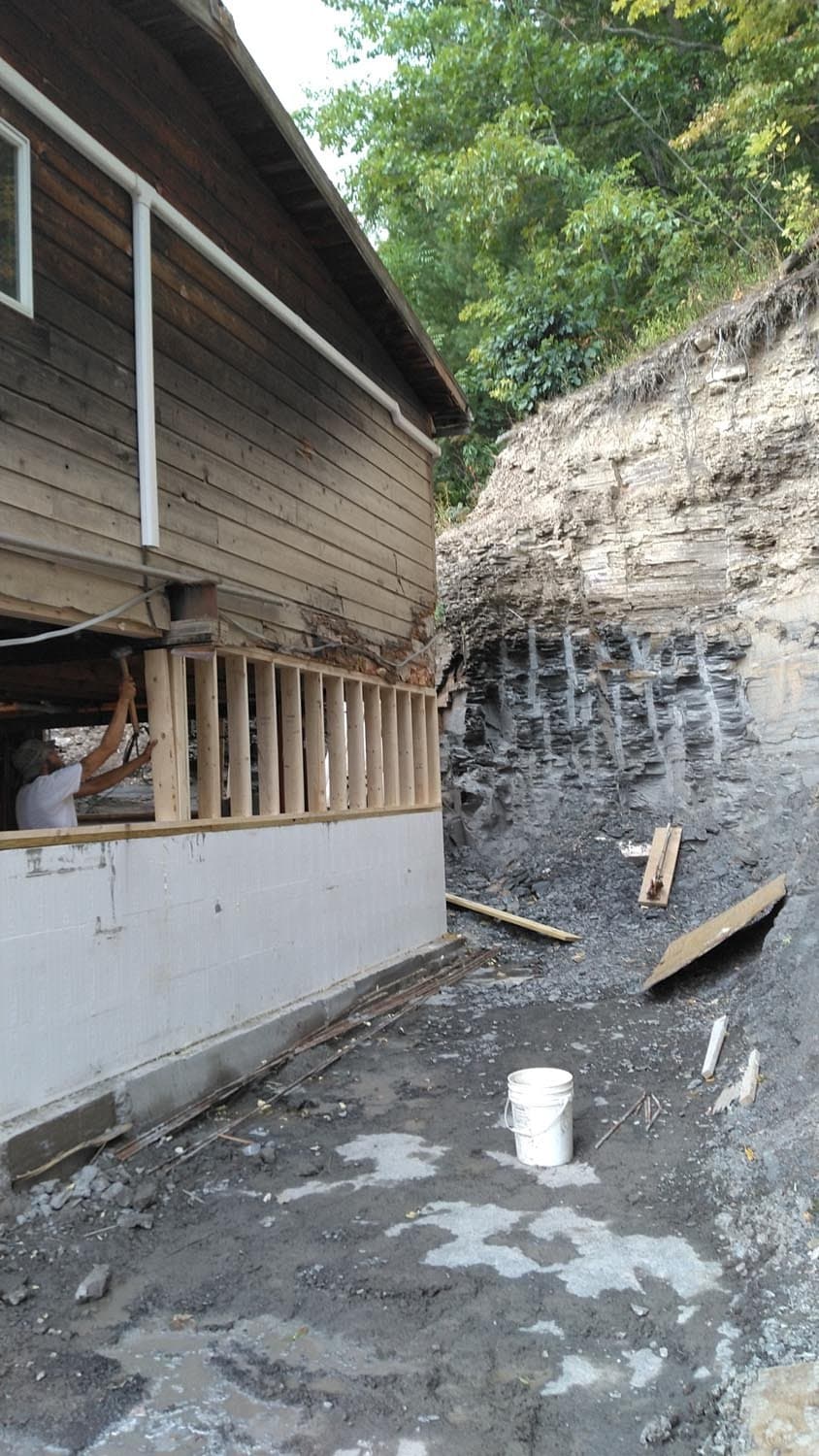 Foundation excavation site with wooden structure and exposed rock wall