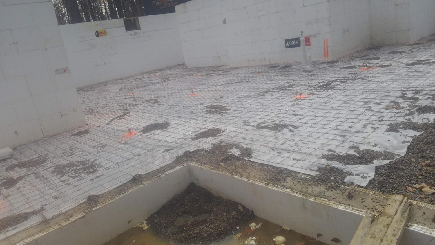 Concrete foundation with radial heating grid and orange markers during installation