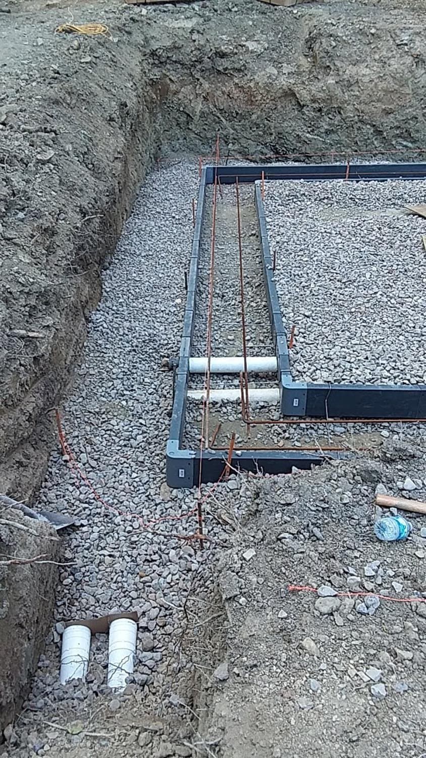 Steel rebar framework installed in gravel-filled foundation footings
