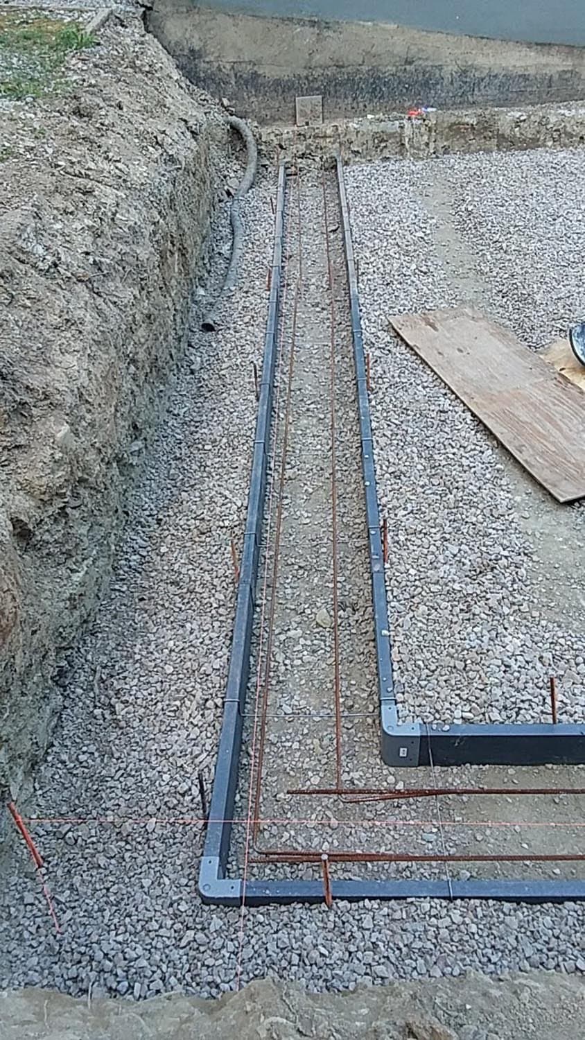 Foundation trench with rebar reinforcement laid on gravel base