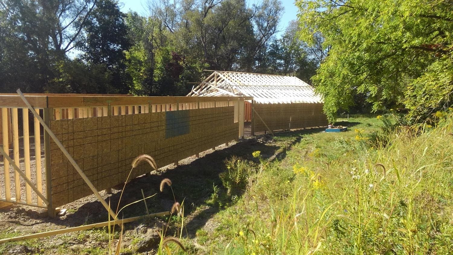 Concrete block foundation walls being built for pole barn with wooden frame structure