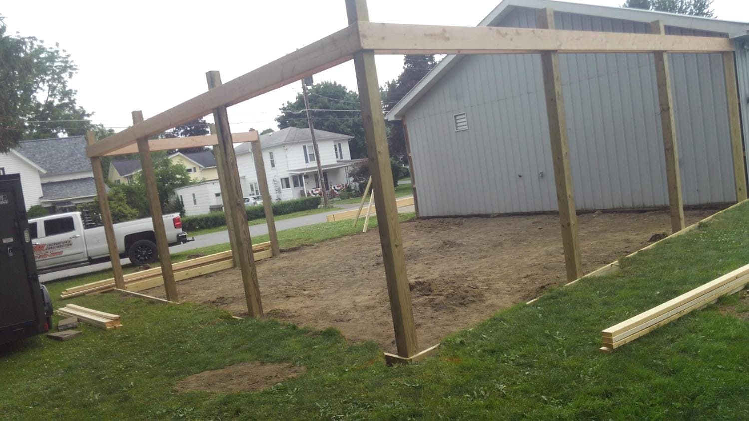 Wooden frame of pole barn under construction in residential backyard