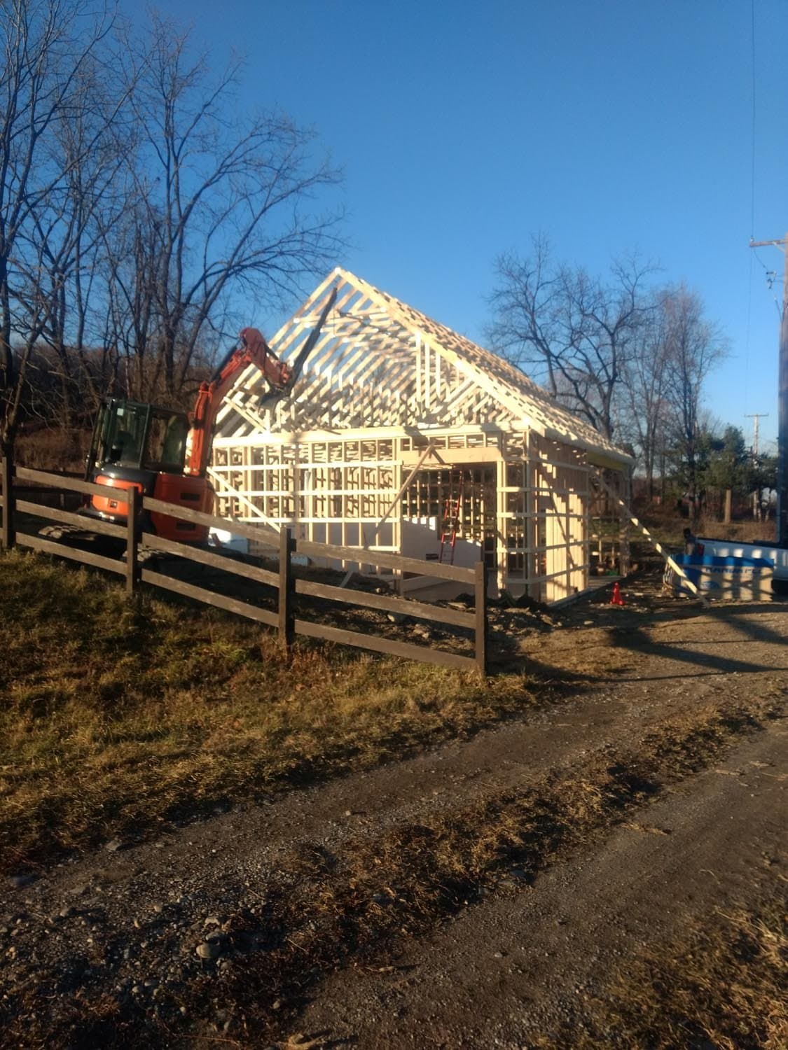 Wooden pole barn frame under construction with exposed roof trusses and rafters