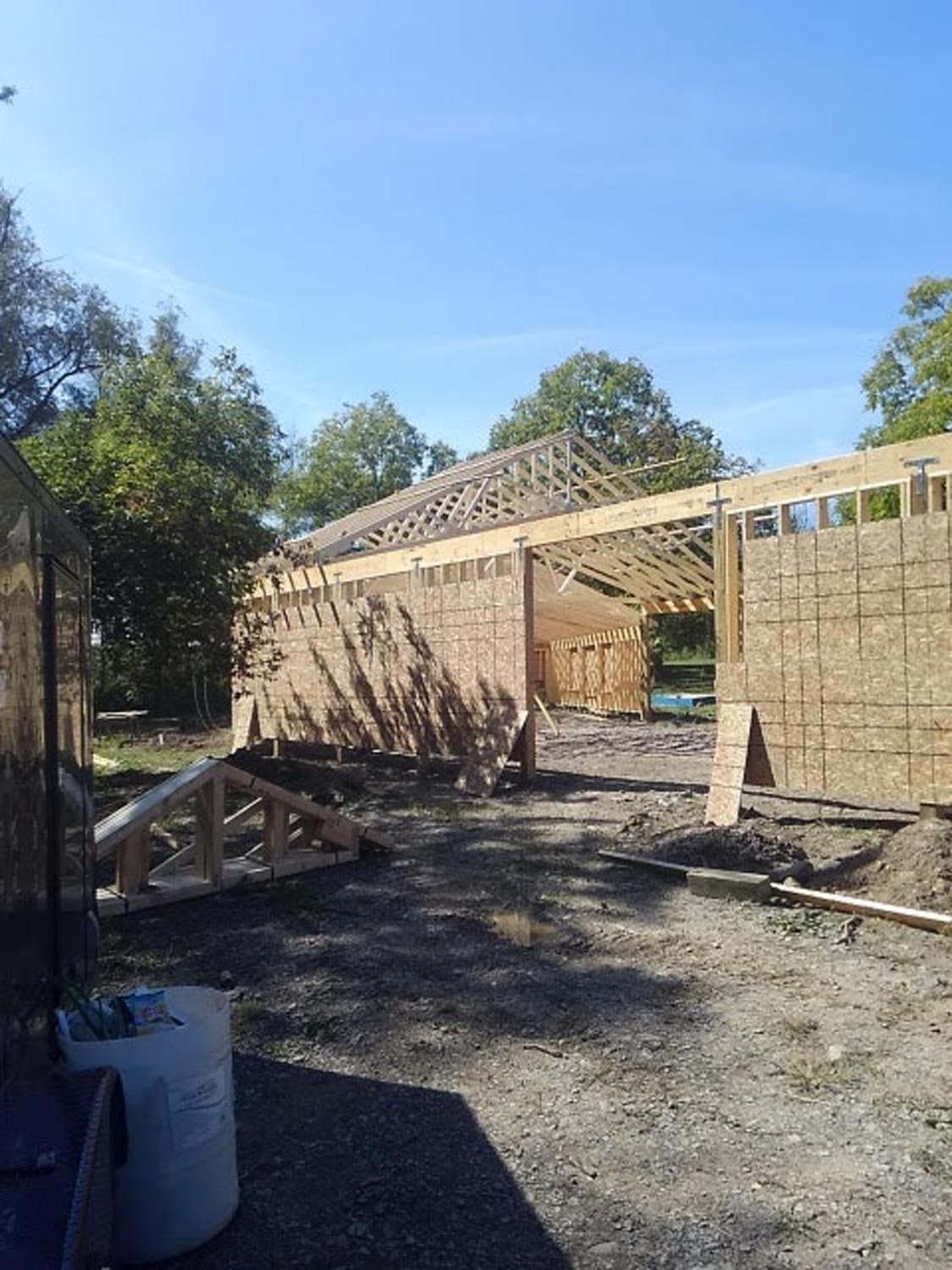 Pole barn under construction showing exposed roof trusses and wall framing